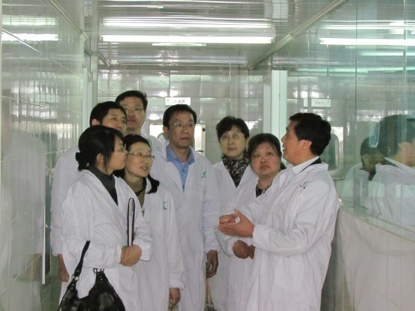 公司副总经理尹宜农(右一)向相关领导介绍昆虫养殖及病毒生产相关情况